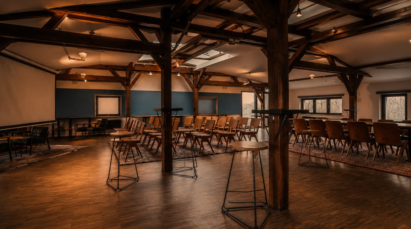 Conference room with seating, wooden beams, standing tables and daylight