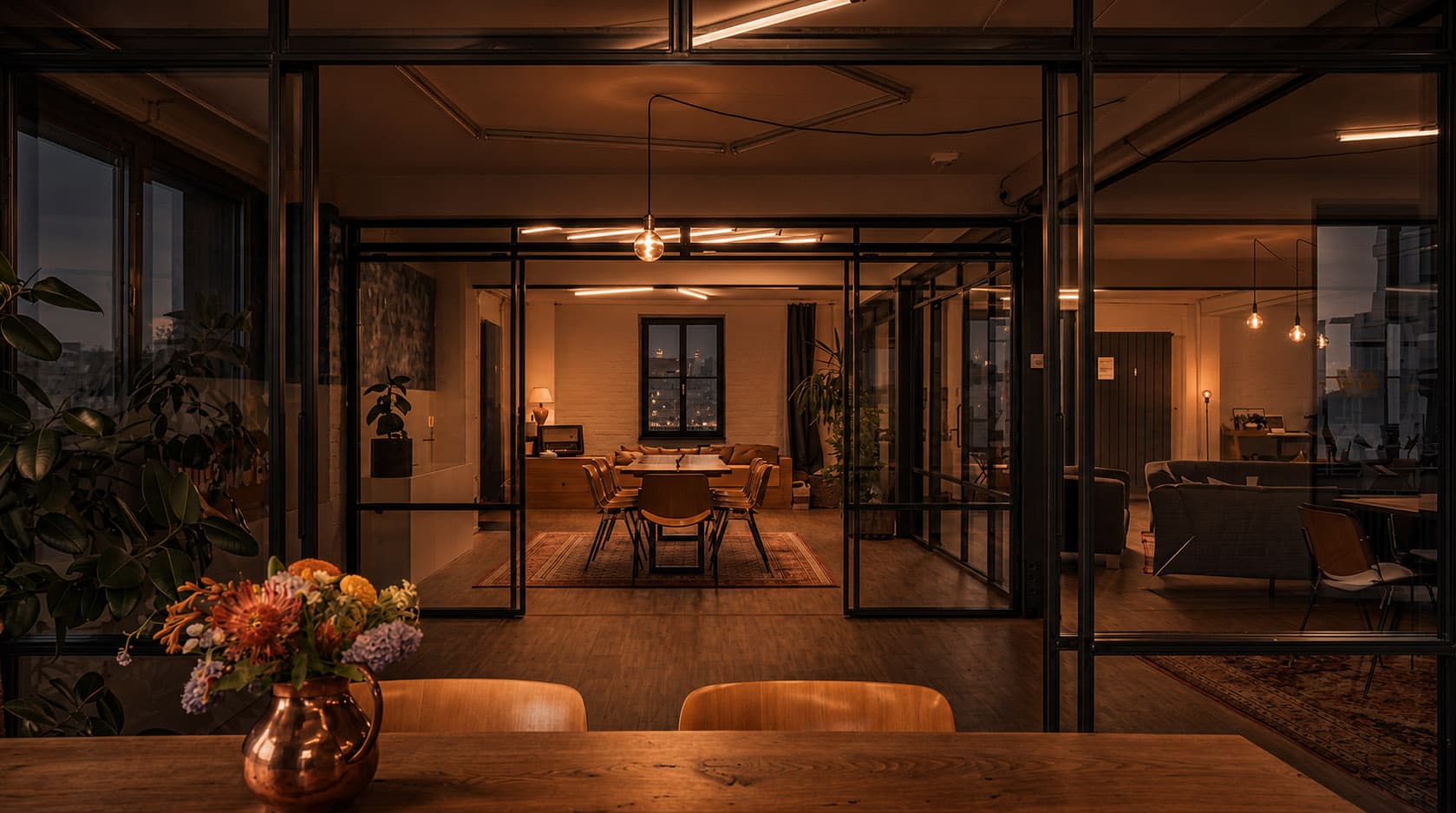 Industrial loft with glass partitions, a long table and warm light