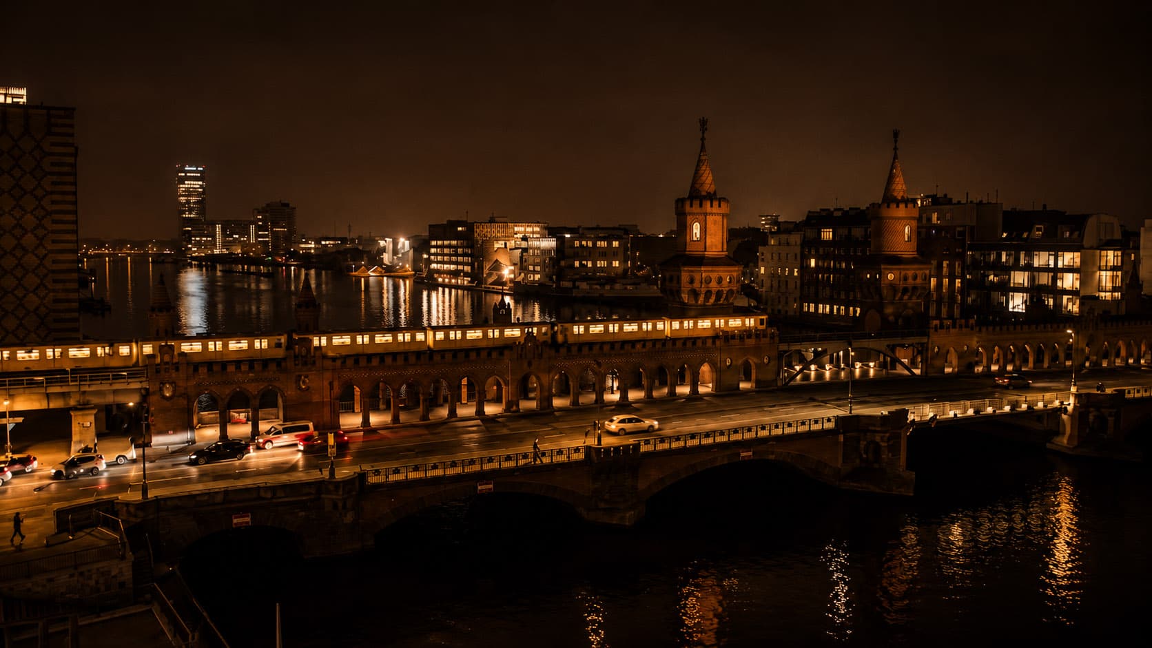 The Oberbaumbrücke at night with the illuminated skyline along the Spree